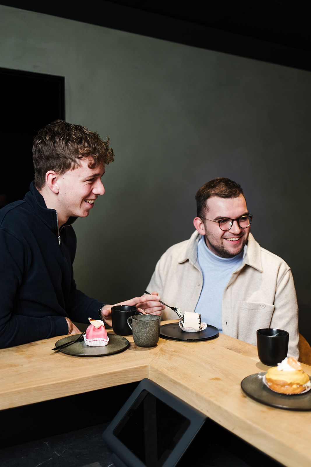 2 mensen hebben aan de bar een lekker gebakje.